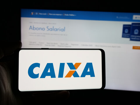 Stuttgart, Germany - 12-02-2025: Person holding smartphone with logo of Brazilian Caixa Economica Federal (CEF) on screen in front of website. Focus on phone display.