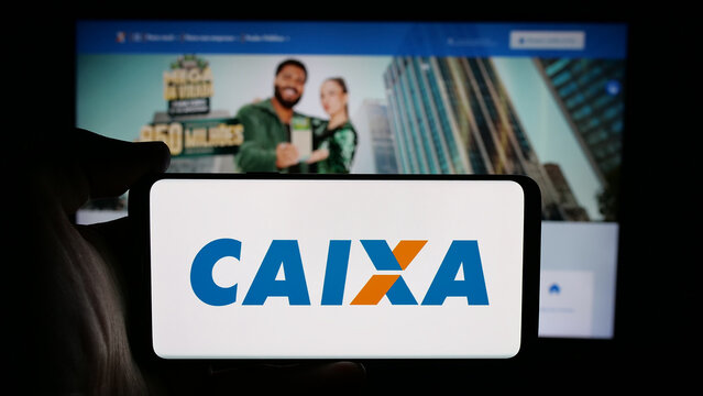 Stuttgart, Germany - 12-02-2025: Person holding cellphone with logo of Brazilian Caixa Economica Federal (CEF) on screen in front of webpage. Focus on phone display.