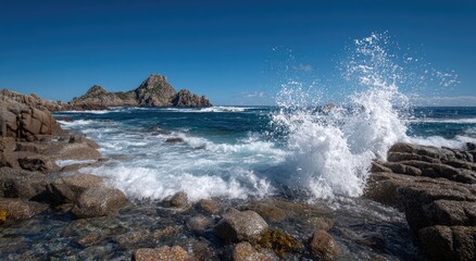Fototapeta premium Rugged rocky coastline with crashing waves under a clear blue sky