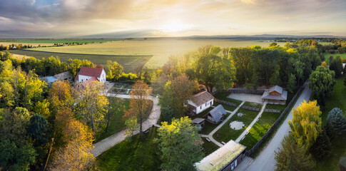 Landscape panorama aerial of village Pac - Archeopark at sunset with forest and field