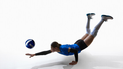 Female volleyball player diving forward with legs raised attempting ball save. Concept of motion analysis, injury-prevention demos, coaching videos, youth training, dynamic sports marketing.