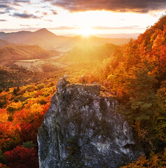 Man photographer in the mountains in autumn at sunset