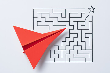 Red paper airplane over maze self learning development concept for education and problem solving inspiring creativity and growth