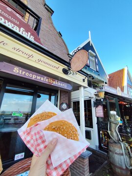 Volendam, Netherlands - October 27, 2025: Classic Stroopwafel in hand. Traditional sweet food stroopwafels with caramel in Holland. Dutch Cookies bakery