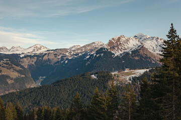 Snow-capped mountains and forested valleys near Les Gets, French Alps, under clear winter skies