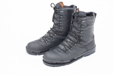 Military-style boots with a frayed sole sit on a snow-covered ground. The scene captures the chill of winter and the wear of the footwear.