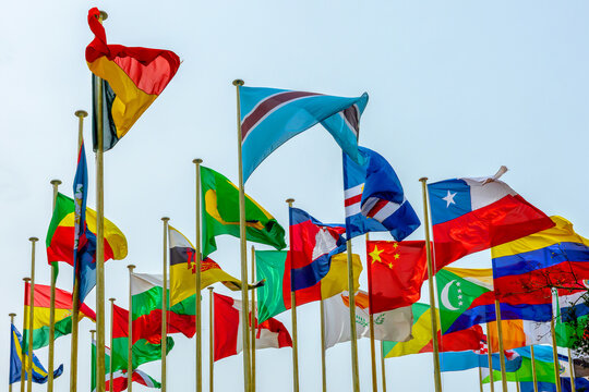 Many poles with flags of countries and all nations members of UN (United Nations) floating in the wind, international organisation, peace symbol