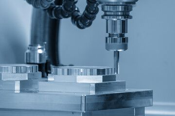 The CNC milling machine cutting  aluminum part by solid flat nose end mill tool in the light blue scene.