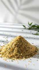 A textured mound of golden breadcrumbs seasoned with vibrant green herbs on a bright white surface