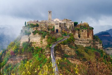 Fototapeta premium Civita di Bagnoregio, Italy – The ancient hilltop village surrounded by morning fog and dramatic landscape.