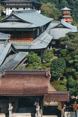 Japanese temple complex with pagoda nestled in lush green forest, Kumano Kodo