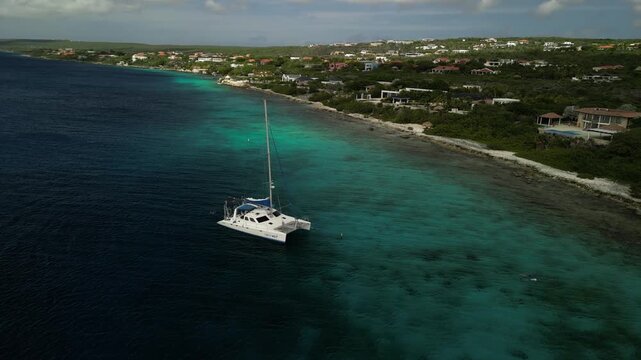 Aerial 4K clip of a white catamaran anchored near the Andrea coastline in bright turquoise water with perfect sunny Caribbean colours.