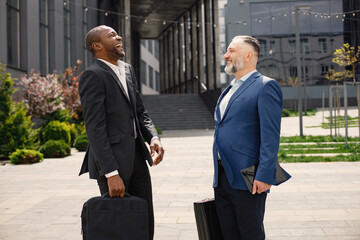 Business people standing and talk to each other in front of modern office