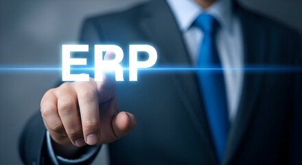 Businessman in a suit points to the glowing white acronym ERP displayed digitally on a dark background symbolizing enterprise resource planning and system integration technology