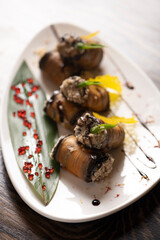 Baked eggplant rolls on a white plate .