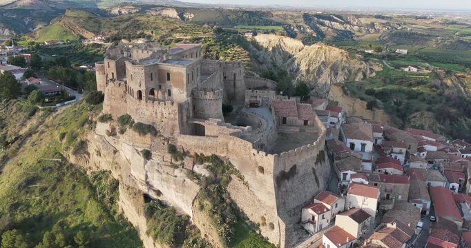 Aerial view of the formidable Rocca Imperiale Castle perched atop a hill overlooking the terracotta rooftops of the town below, Rocca Imperiale, Calabria, Italy.
