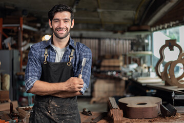 Portrait of guitar luthier small business owner in workroom.