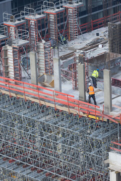 Bauarbeiter arbeiten auf einer Gro&szlig;baustelle an einem B&uuml;rogeb&auml;ude