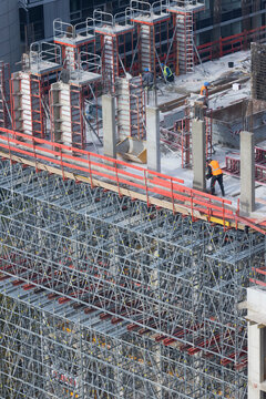 Bauarbeiter arbeiten auf einer Gro&szlig;baustelle an einem B&uuml;rogeb&auml;ude