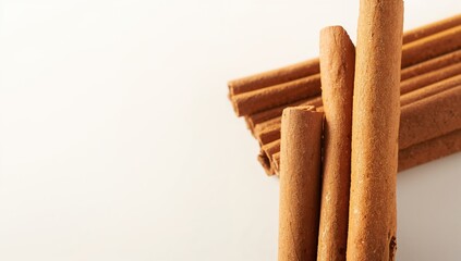Cinnamon sticks laid out on a white surface, natural spices for culinary use