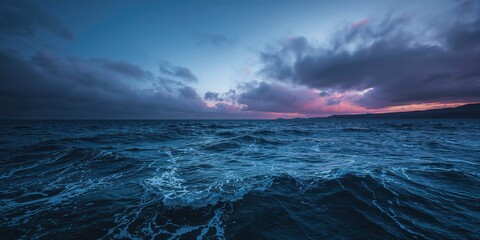 Overhead shot of a windy blue bay with turbulent waters and a dramatic sky, highlighting weather conditions affecting coastal areas