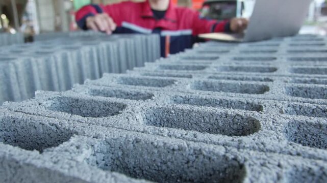 Foreman Inspecting Concrete Blocks at Construction Site