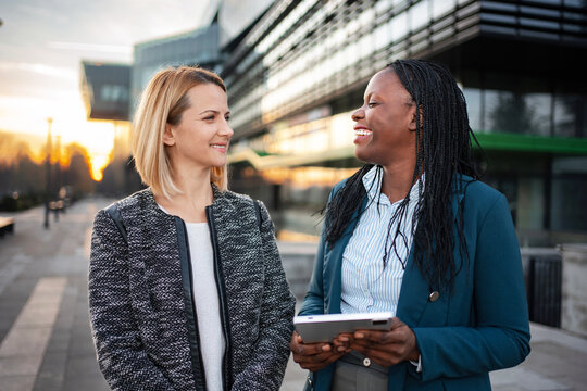 Diverse businesswomen colleagues discussing work using digital tablet - Powered by Adobe