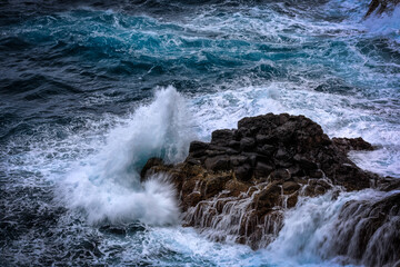waves of the atlantic ocean crashing on rocks at madeira portugal