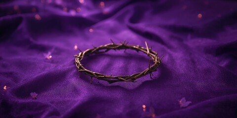 Religious crown of thorns resting on a purple surface, used in Easter rituals or Lent traditions