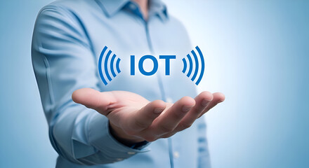 Businessman presents the concept of internet of things iot technology symbolized by glowing blue text and wireless signals held above an open palm against a light blue background