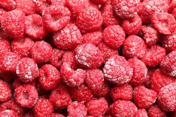 Frozen ripe raspberries as background, top view
