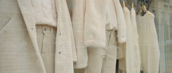 Vitrine de magasin où sont exposés des vêtements blancs, format bannière