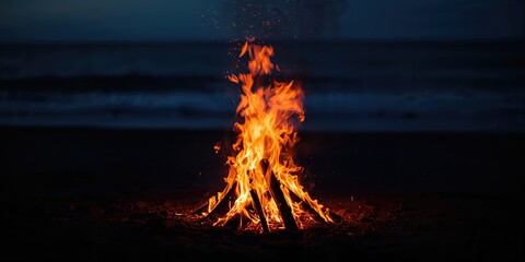 Close-up of beach fire showing glowing embers and flickering flames, outdoor safety awareness
