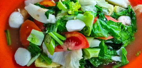 The typical Asian stir fry dish, Cap Cai or Capcay, is served in a reddish orange bowl