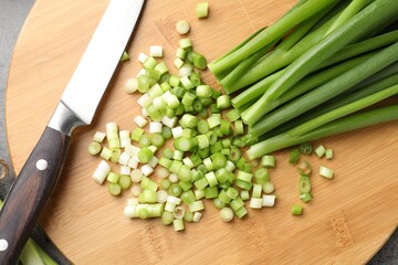 Green onions and knife on table, top view
