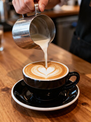 Barista Pouring Milk to Create Latte Art in a Cup of Coffee