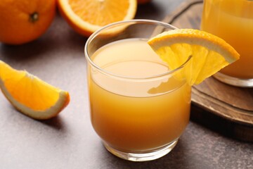 Fresh orange juice and fruits on grey table, closeup