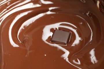 Tasty melted chocolate and piece as background, closeup