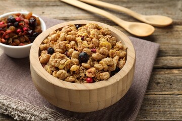 Tasty granola with dried fruits on wooden table, closeup