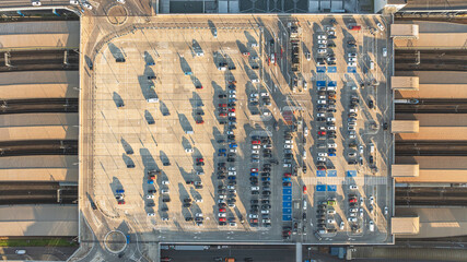 Large parking lot with cars in Krakow, Poland. Railway station under parking lot. Drone flight view.