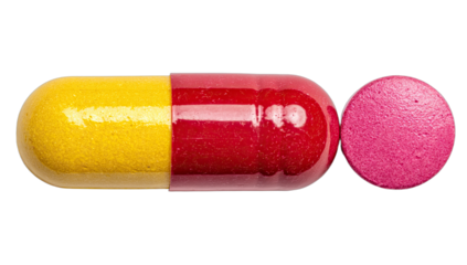 Macro view of a yellow and red capsule next to a pink pill