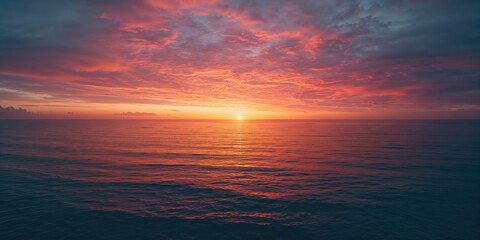 Obraz premium Sunset over ocean with colorful sky and dynamic cloud patterns, ideal for nature-inspired backgrounds