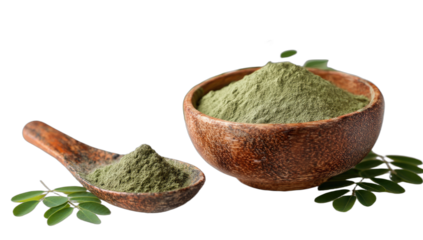 Rustic wooden bowl and spoon filled with finely ground green powder, surrounded by fresh leaves