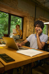 Man multitasking, phone call and laptop work