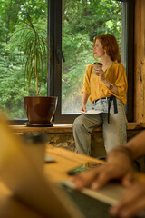 Caucasian woman standing casually, holding a paper