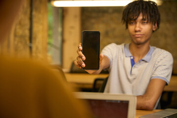 Adult man presenting his phone screen to a colleague