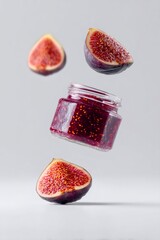 Fig jam jar and fresh fig halves levitating, representing homemade preserve, delicious sweet fruit food