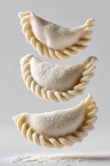 Frozen pierogi dumplings levitating, showcasing raw dough and flour, ready for cooking as a traditional meal