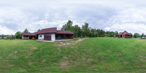 Seamless spherical HDRI panorama with a 360-degree angle view of a green lawn and a house in the background. Green lawn, green paddock. VR content.