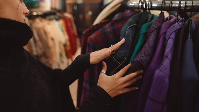 Customer evaluates checked and plain outerwear amidst cozy shop setting